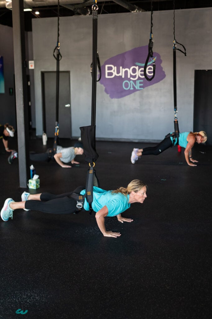Woman doing a suspended push-up in a bungee harness